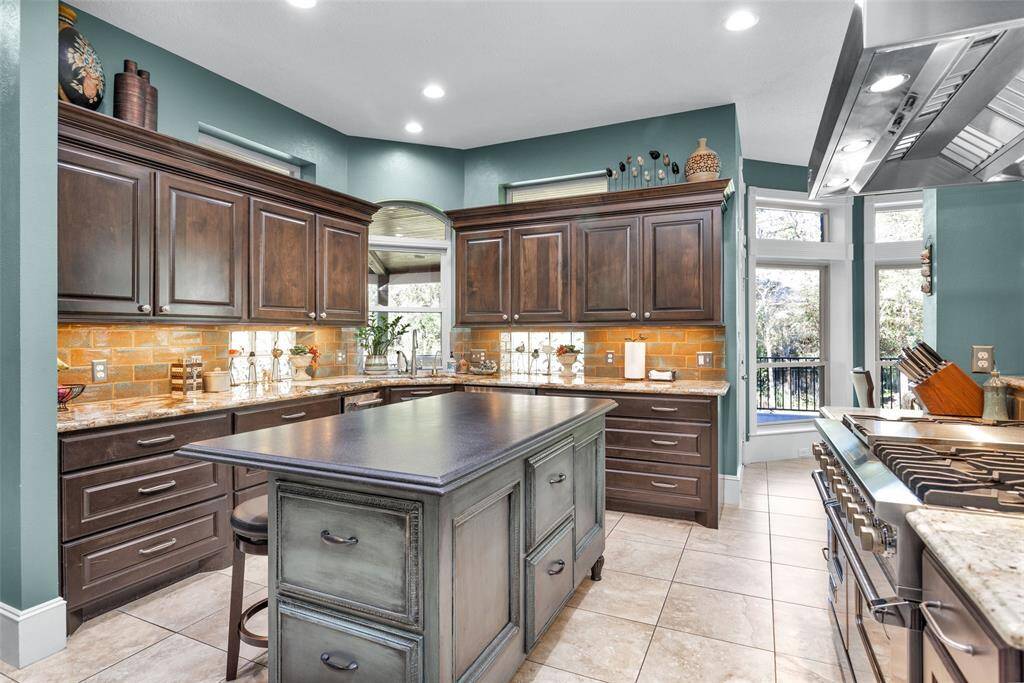 Central, custom, island kitchen with 48" Viking gas range with double ovens