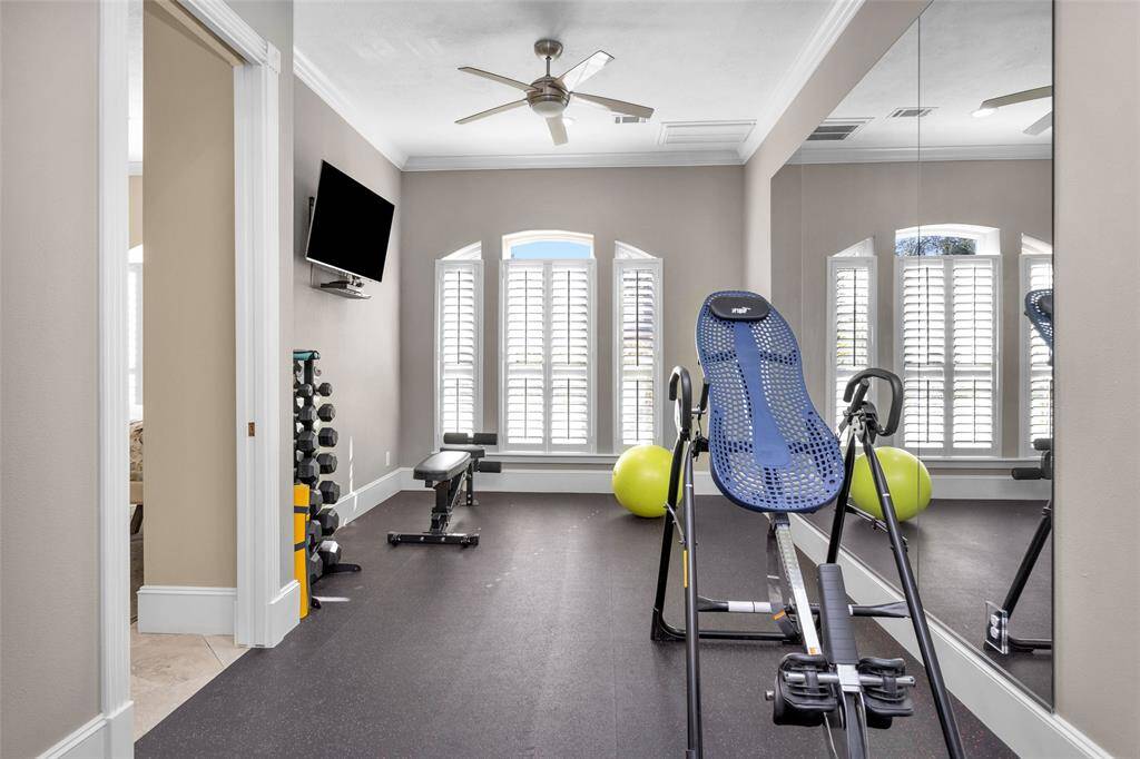 Exercise room with rubberized floor between the guest suite and the utility room. Wall-mounted TV included