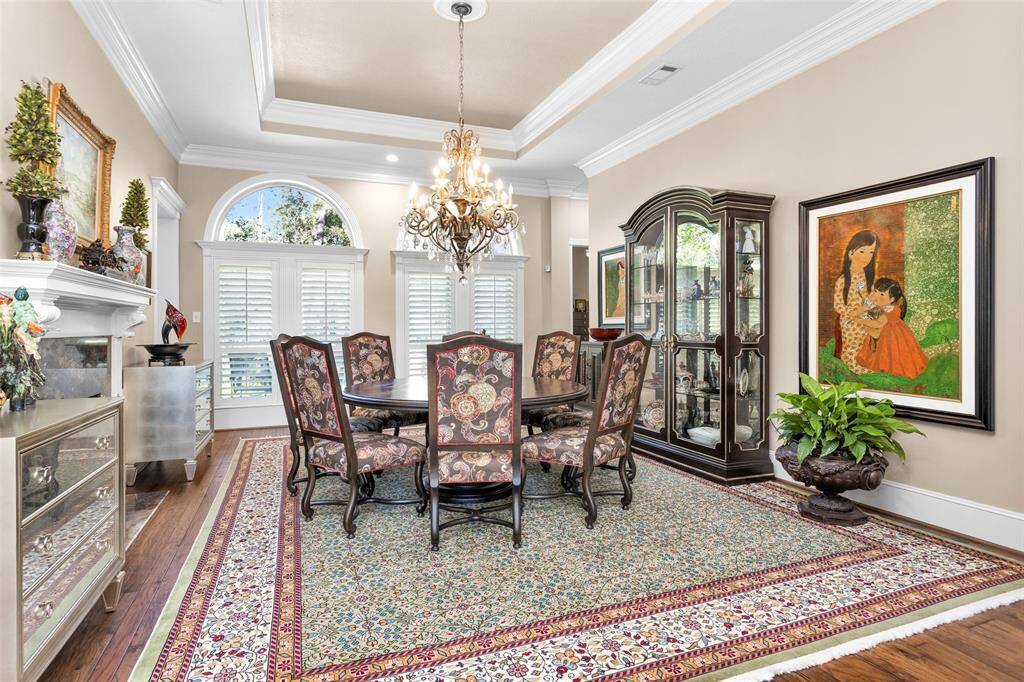 Elegant formal dining room shares a double-sided fireplace with the family room. Chandelier stays.