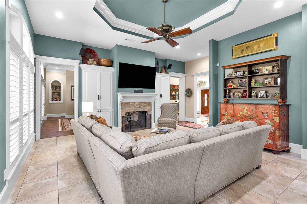 Family room shares the double-sided fireplace. Recessed ceiling feature
