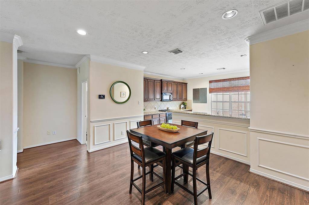 This inviting dining area features elegant wood flooring and wainscoting.