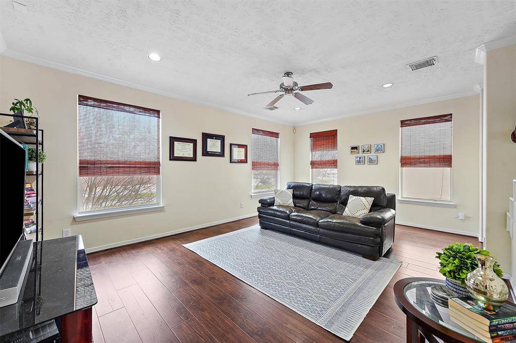 Bright spacious living room with large windows and beautiful wood floors.