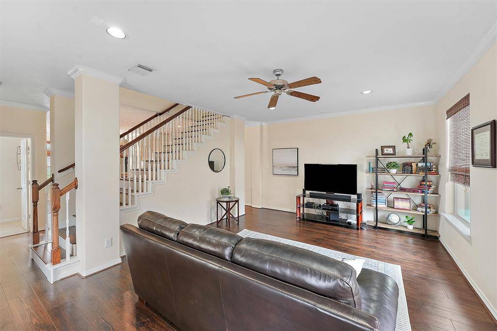 Second level staircase provides a slight separation and design element between the living space and the dining and kitchen area.