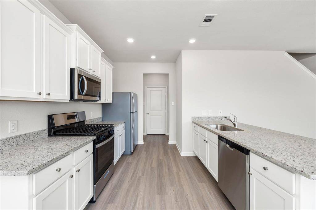 The kitchen comes equipped with Whirlpool appliances and granite countertops.