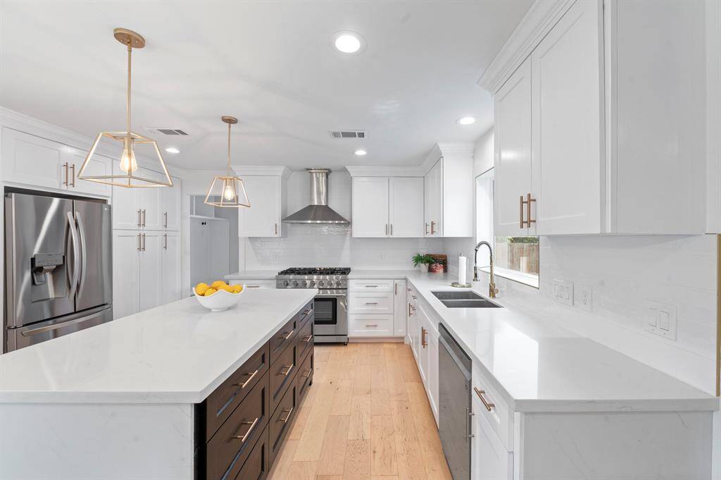 This dreamy kitchen checks every box—stainless steel appliances, designer lighting, and a massive island with stylish contrast cabinetry.