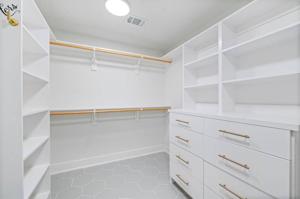 No shortage of storage here! Custom built-ins, drawers, and hanging space make this walk-in closet as functional as it is fabulous.