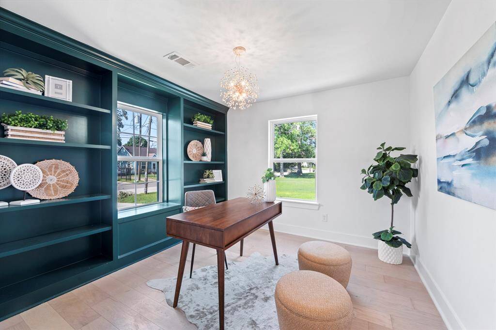 This cheerful home office features bold built-ins, natural light, and a statement chandelier! Style meets productivity in the best way!