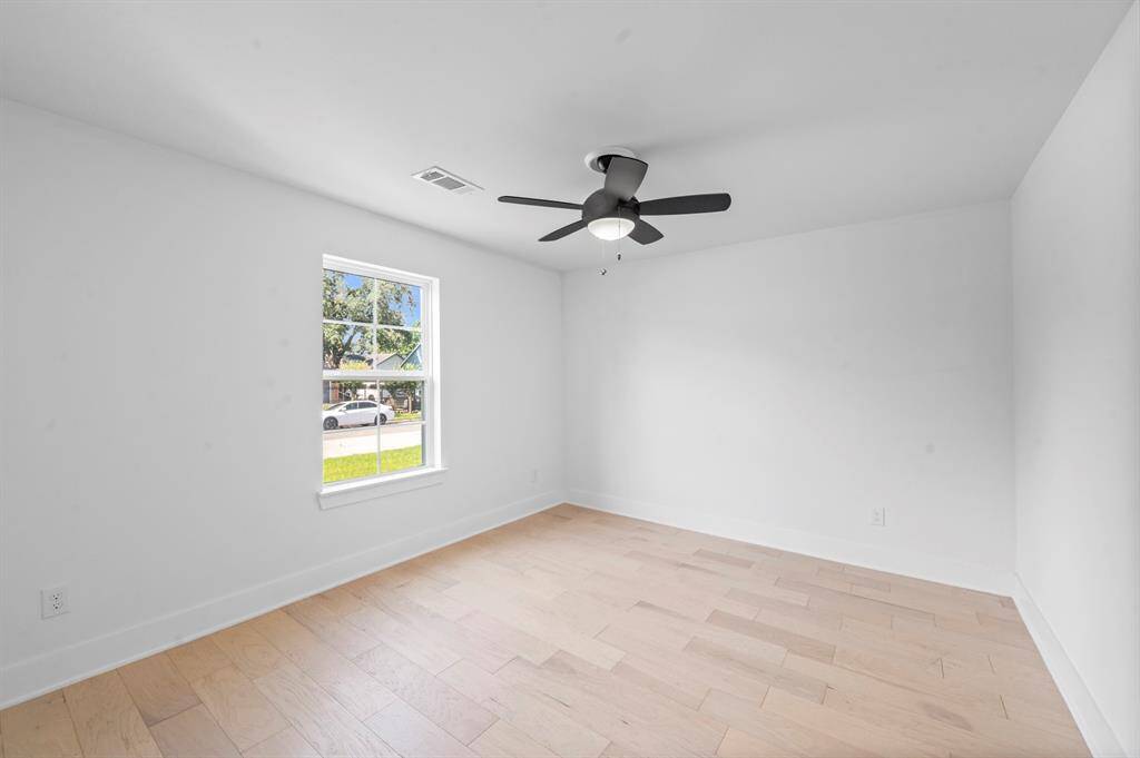 Light and airy with hardwood floors, a ceiling fan, and a great front yard view—this room is ready to fit your lifestyle.