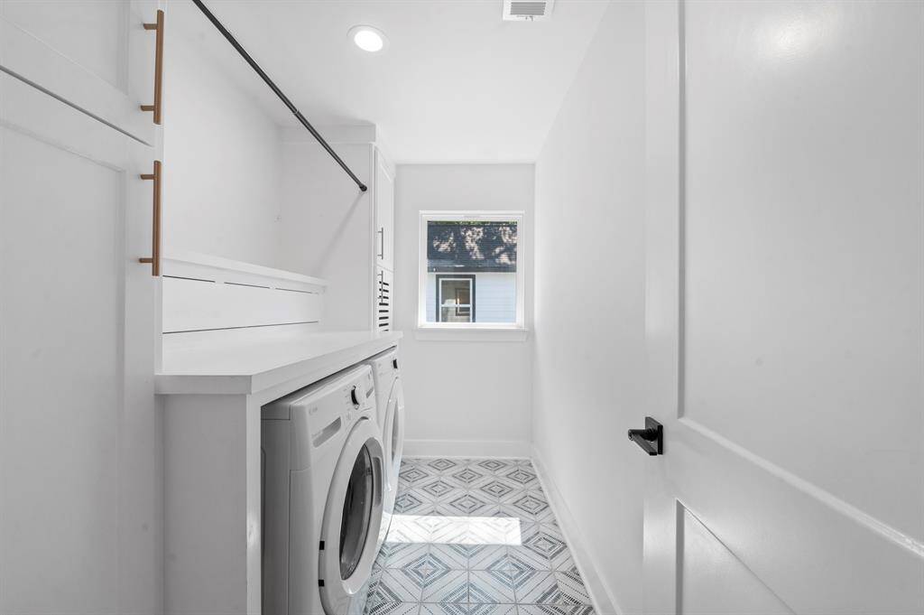 Even laundry day feels brighter in this sleek utility space, complete with patterned tile, hanging bar, and built-in storage.