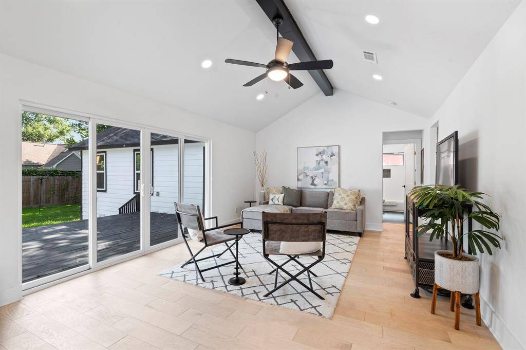 Massive sliding glass doors flood the room with natural light and open directly onto the deck for effortless indoor-outdoor living.