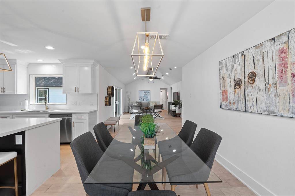 The seamless flow from dining to living makes entertaining a breeze— statement light fixture helps define the space