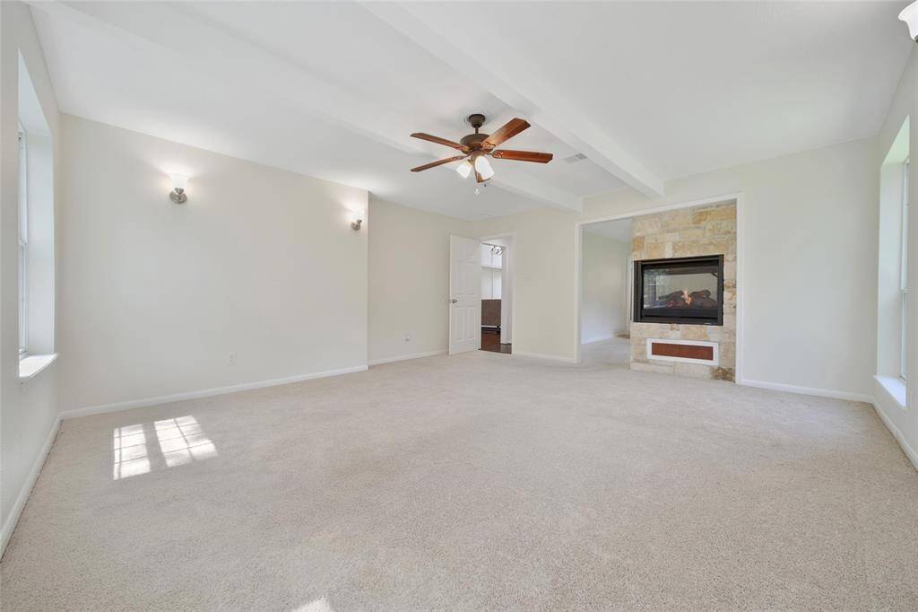 Primary retreat with natural light and a cozy fireplace.