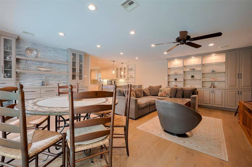 Wall of built ins and wood floors throughout remodeled family room