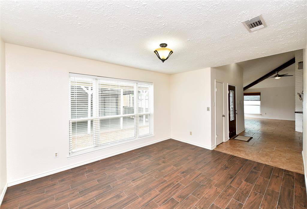The formal dining room has upgraded hand scraped wood-look tile floors, recently installed.  Expansive windows add lots of light!