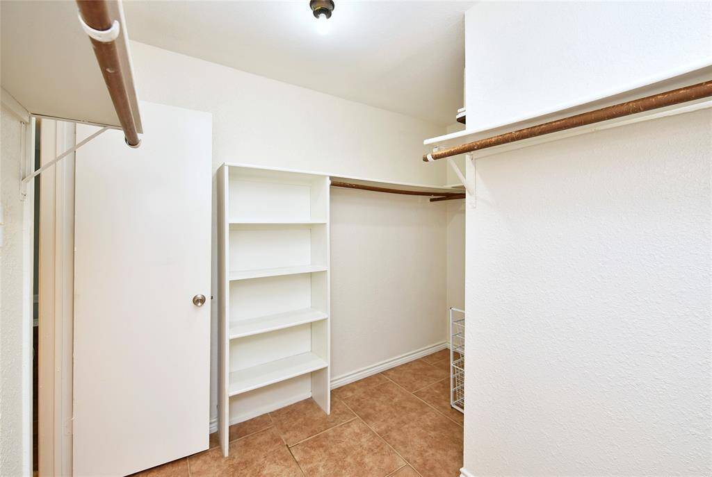 The primary bedroom features a huge walk-in closet, with built-in shelving and plenty of hanging space.