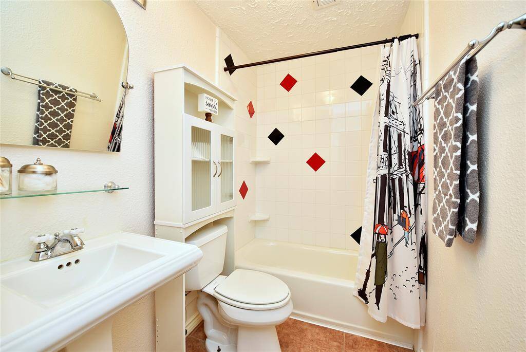 Bright and cheerful second full bath, features a pedestal sink and storage behind the potty.