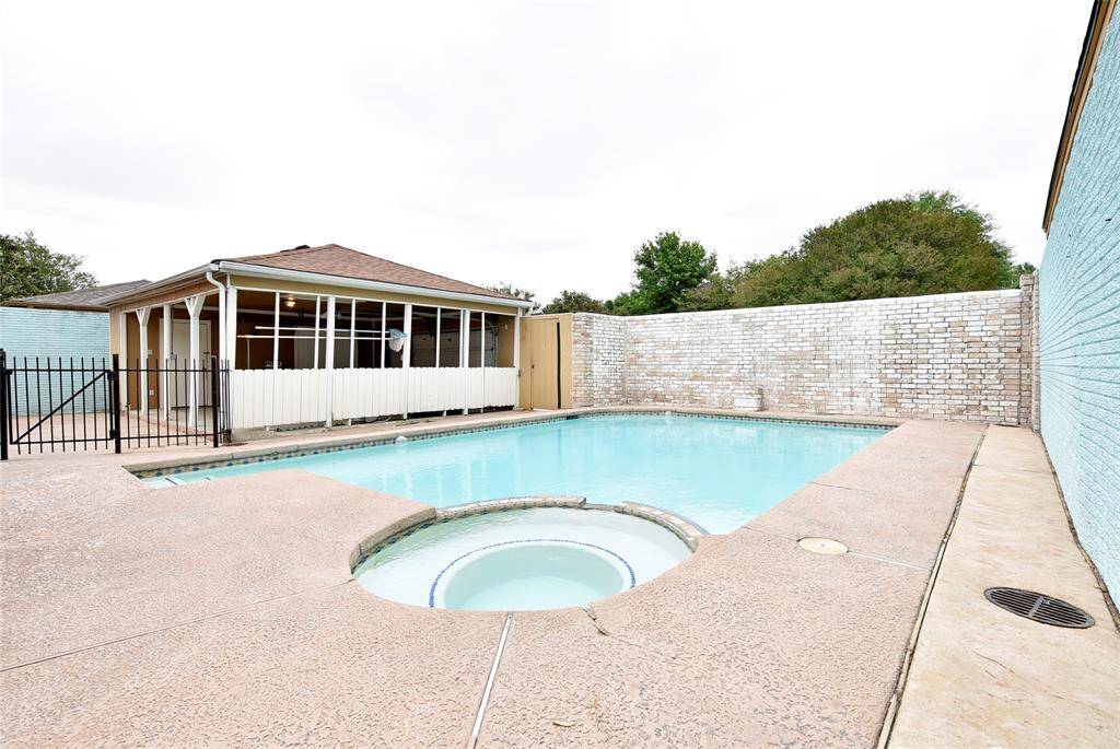 From the house, looking over the spa and pool to the carport area.  Wrought iron gates have a safety feature added.