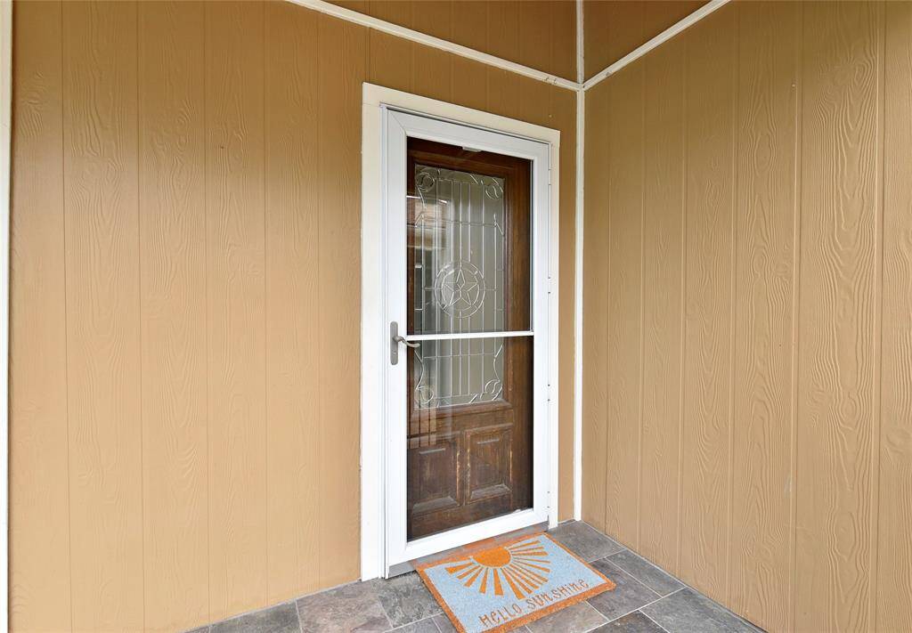 A storm door further protects the leaded glass and mahogany front door.  There's a Ring doorbell with security cameras, as well.