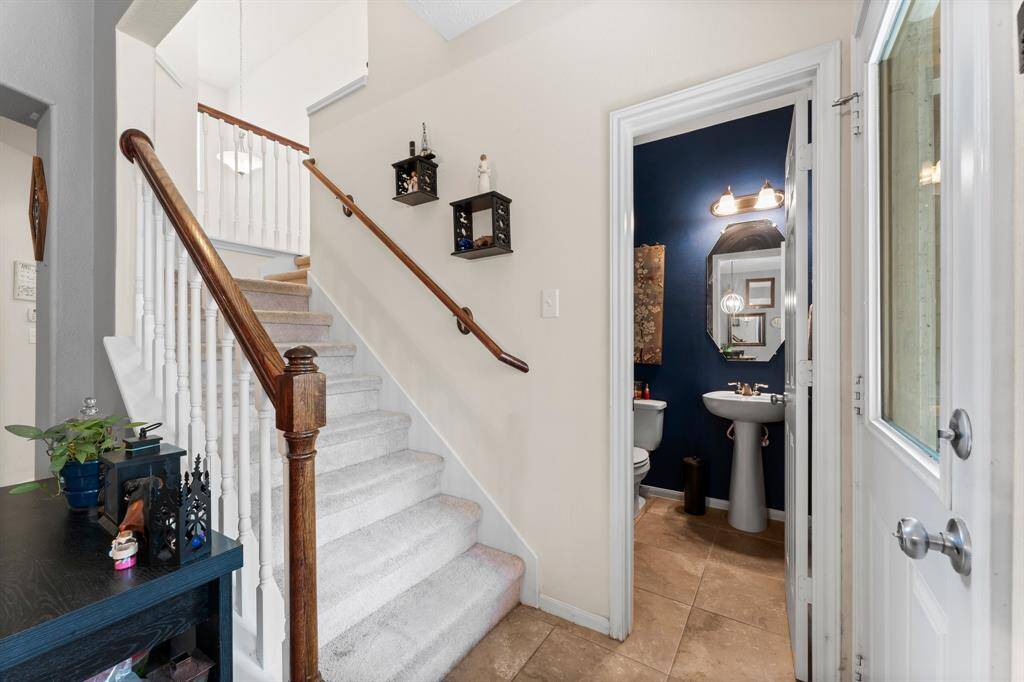 At the base of the stairs is the half bathroom. The door on the right leads out to the covered back patio.