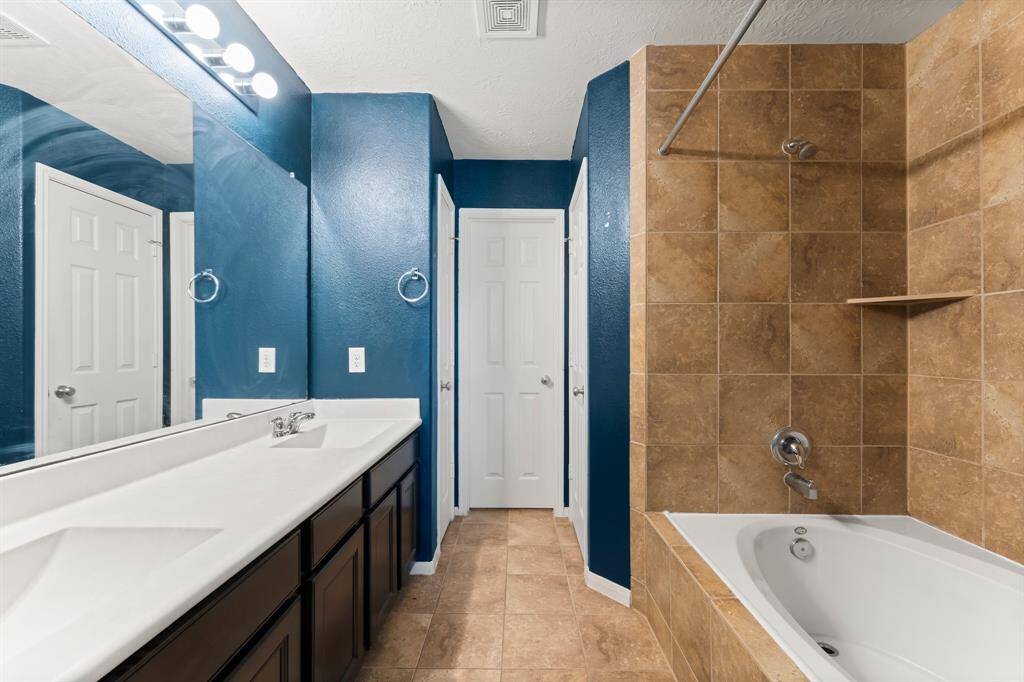 The Primary Bathroom has TWO (2) sinks and a tub/shower combination. Linen closet straight ahead for more storage.