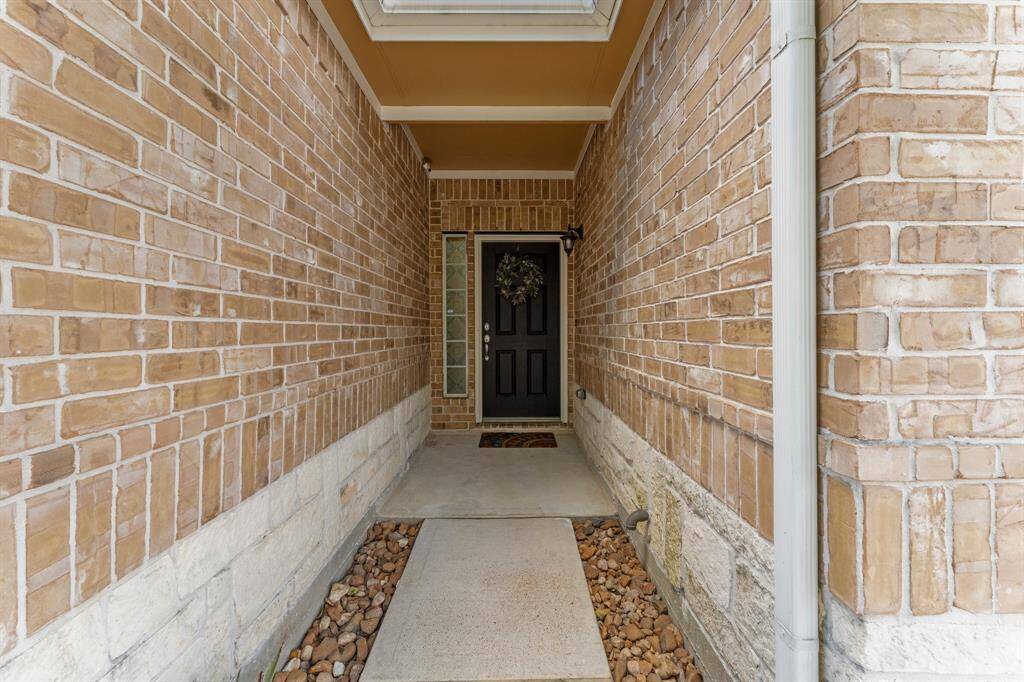 Walking up to the front door, you have a covered front door with stone and brick exterior and bull rock for improved drainage.