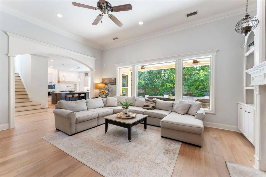 The family room boasts picture-frame windows that offer serene views of the private back gardens and sparkling pool.
