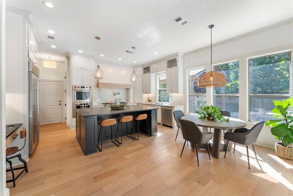 At the heart of the home, the kitchen is anchored by a spacious soapstone countertop island with seating, complemented by a bright breakfast nook that bathes in abundant natural light.