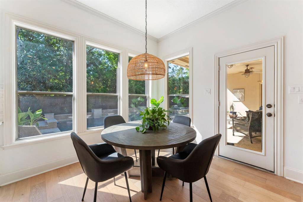 A charming breakfast nook is framed by windows that overlook the backyard, with easy access to the covered patio for effortless indoor-outdoor living.