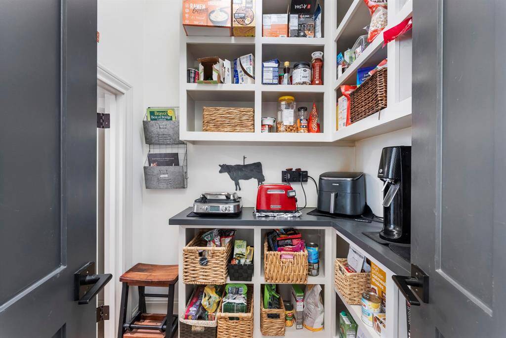 A custom walk-in pantry provides ample storage and organization, perfect for keeping the kitchen clutter-free.