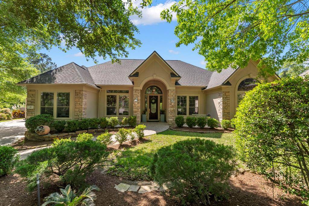 Extensive and mature landscaping surround this beautiful stone and stucco custom Leigh home.