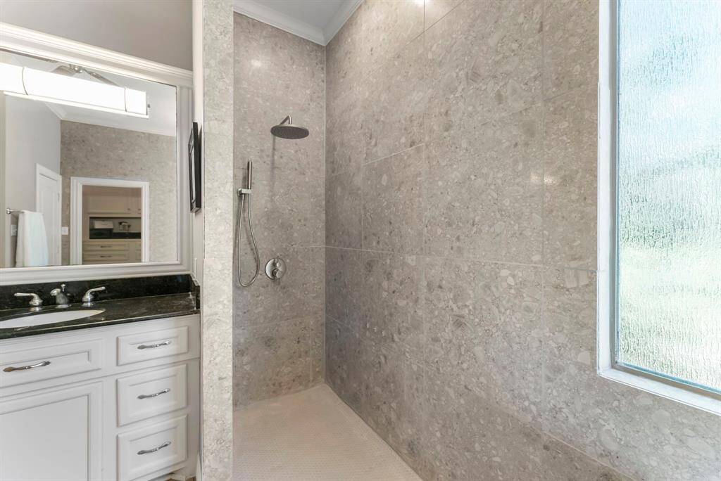 The newly updated walk-in shower features stunning floor-to-ceiling tile, brushed nickel fixtures, and brand-new frameless glass—just installed and not yet captured in photos. A must-see in person!