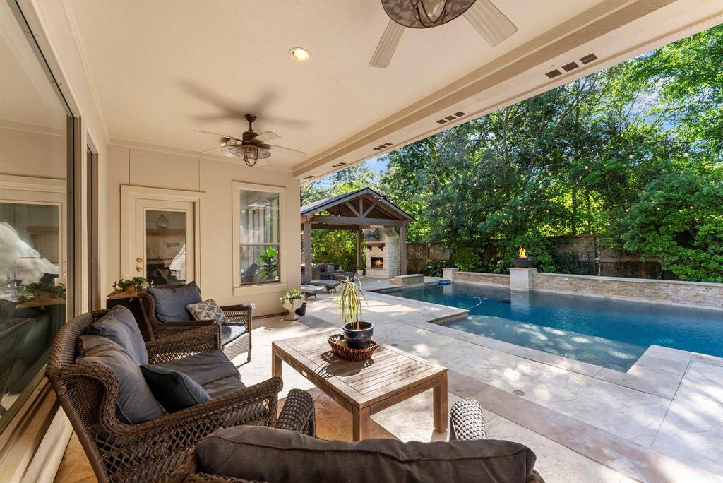 Unwind on the covered back patio, complete with ceiling fans, while enjoying views of the modern, sparkling pool.