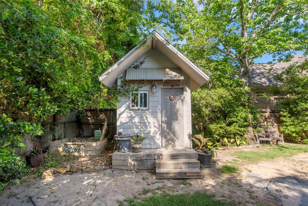 A charming bunkhouse sits at the corner of the backyard, offering a cozy retreat with plenty of space for gardening and outdoor activities.