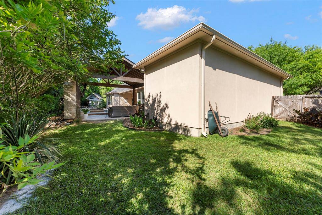 On the left side of the backyard, you'll find lush landscaping and expansive green space.