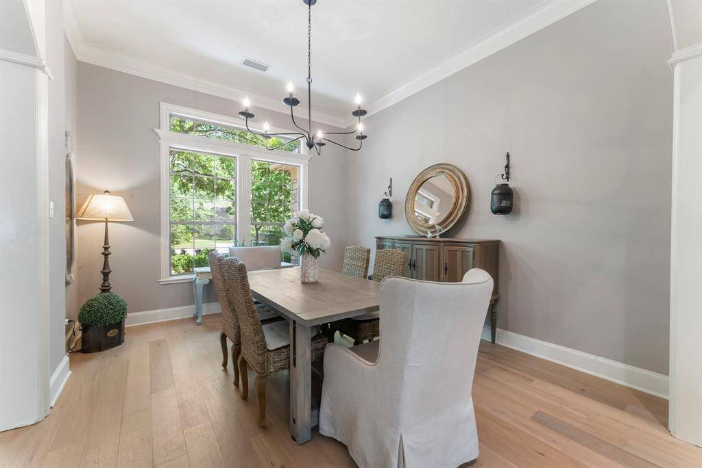 An expansive formal dining room features large windows that frame picturesque views of the front yard.