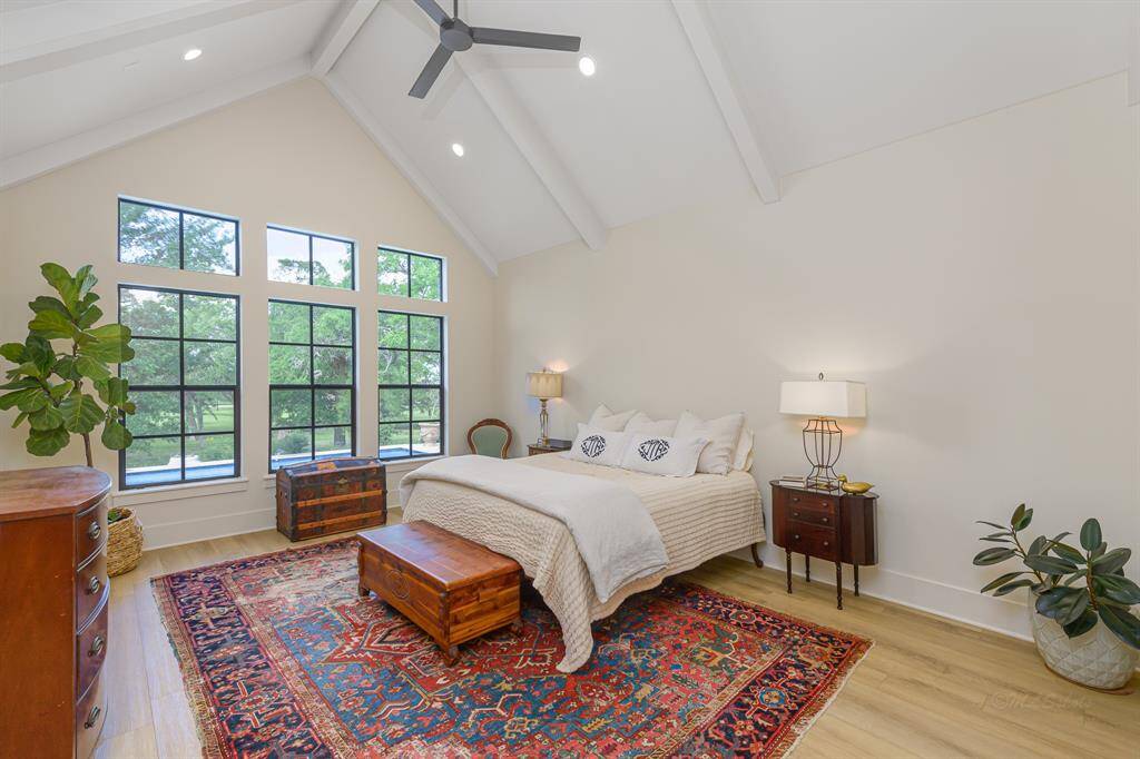Huge primary bedroom with beamed vaulted ceiling...overlooking the pool