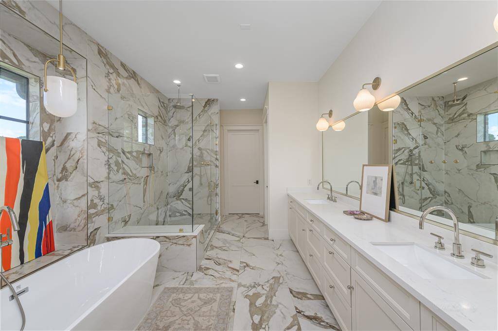 Freestanding tub and dual sinks make this primary bathroom feel like a resort spa.