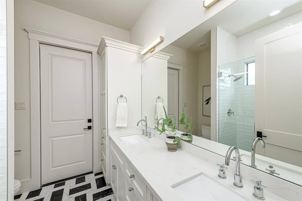 Guest bath with dual sinks and basket weave tile...your guests won't want to leave!