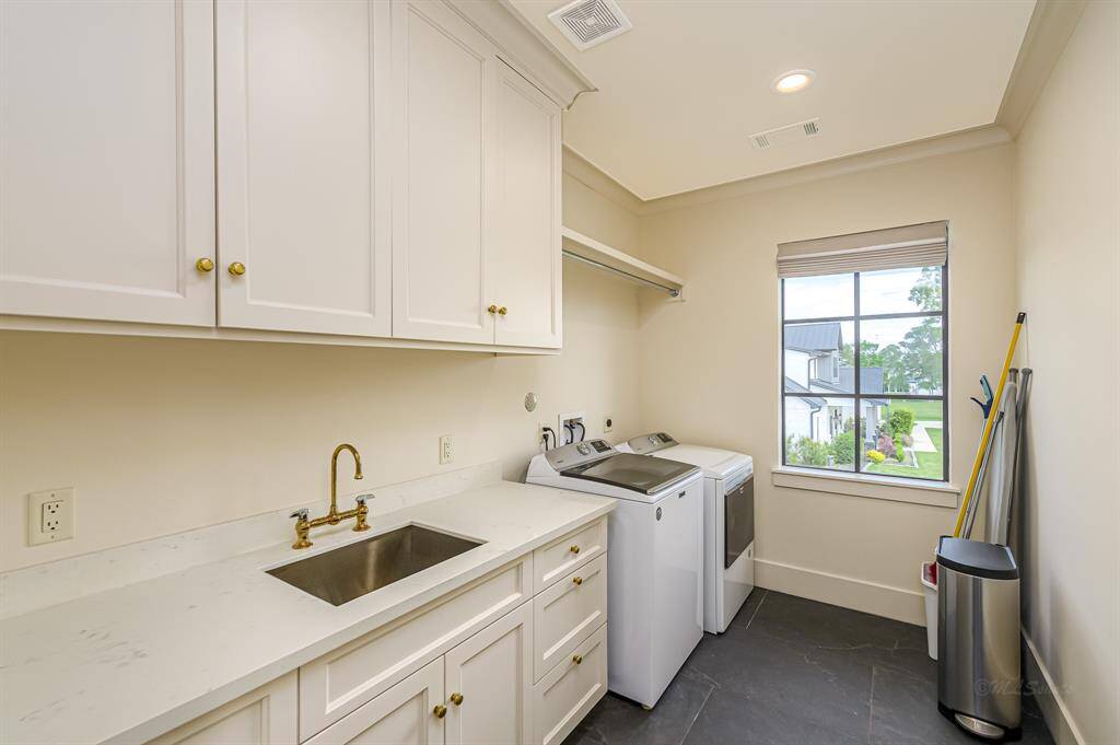 Spacious laundry room with sink, lots of counter space and cabinet storage