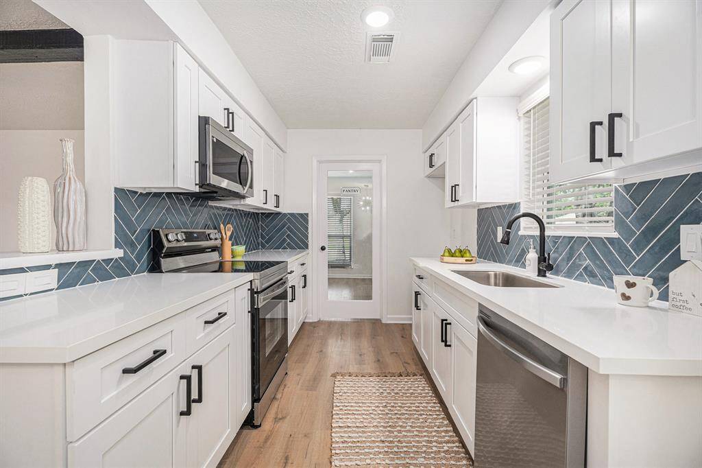 White Quartz countertops and a stunning blue blackspash adorn this kitchen