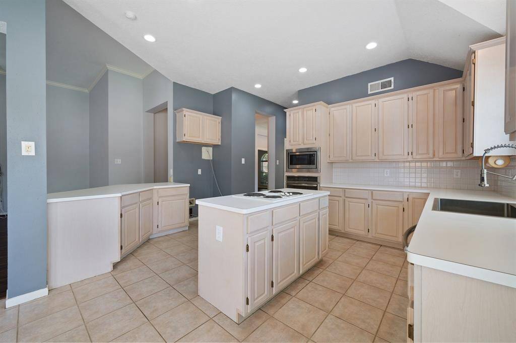 Now you can see how large this kitchen is from breakfast area side. Lots of cabinets and countertops allow for storage, meal prep and serving.