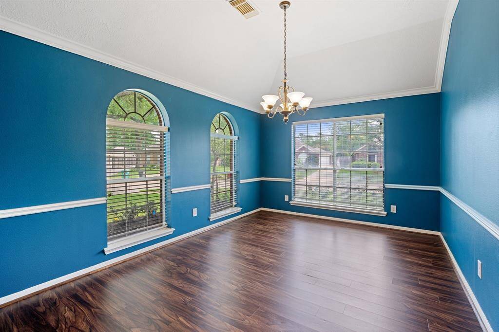 Large formal dining room with vaulted ceilings and crown molding sits off the front of the home. These big windows allow a lot of natural light to come into the space.