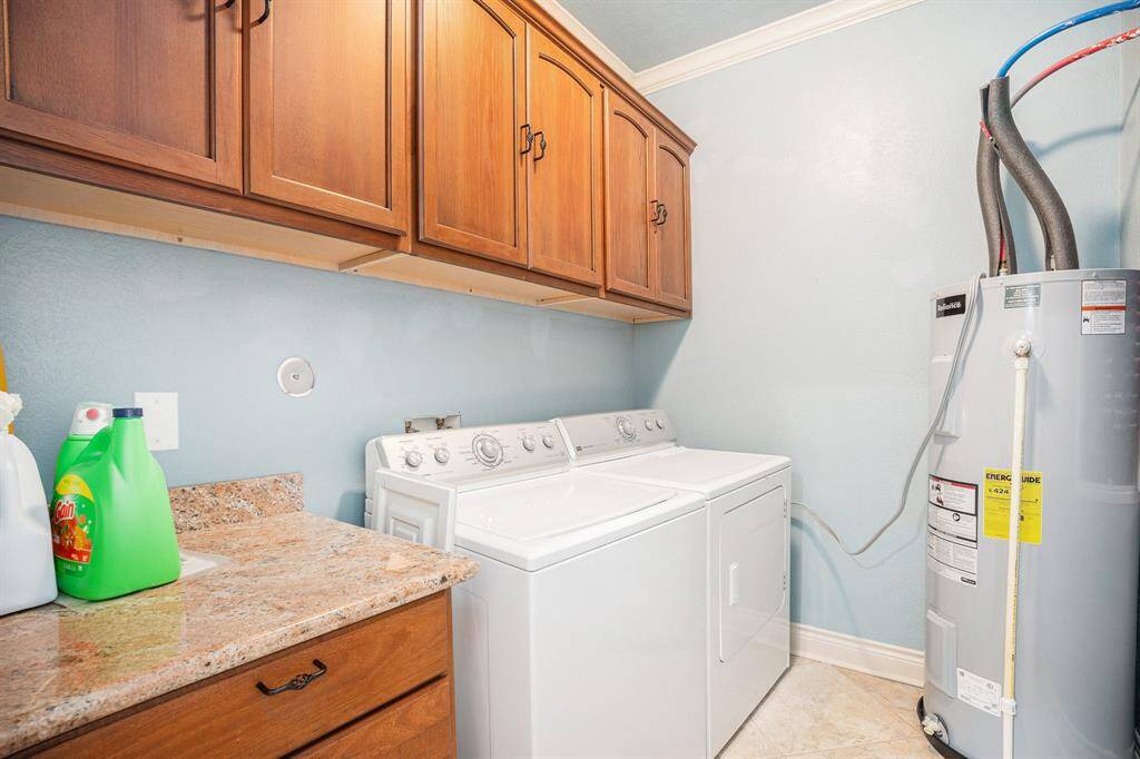 The laundry room is equipped with counterspace and storage space to keep laundry supplies organized and easily accessible.