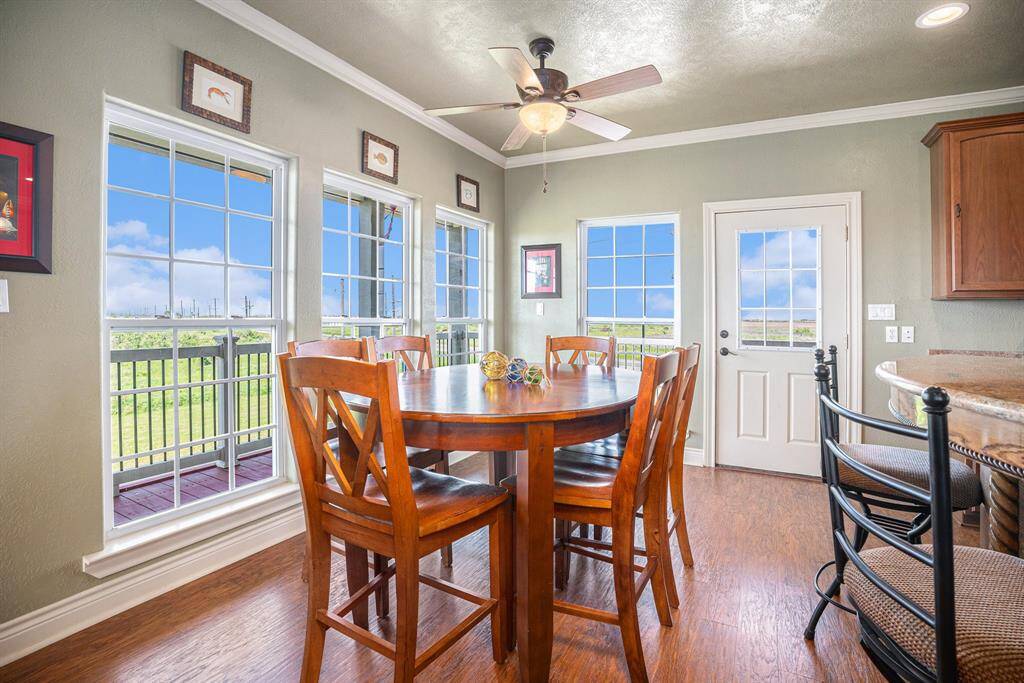 This bright and airy dining area offers a warm and inviting atmosphere. Key features include hardwood flooring, large windows that provide ample natural light and views of the outdoors.