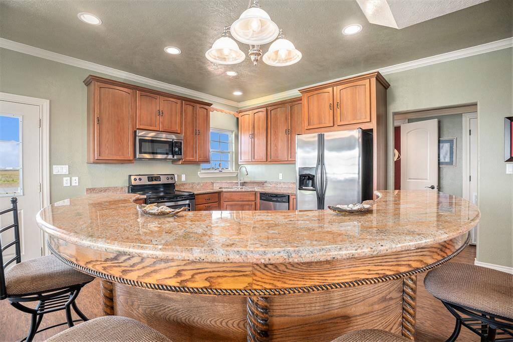 This kitchen boasts beautiful granite countertops, ample cabinet space for storage, and stainless steel appliances. The custom woodwork adds a touch of elegance and sophistication to the space.