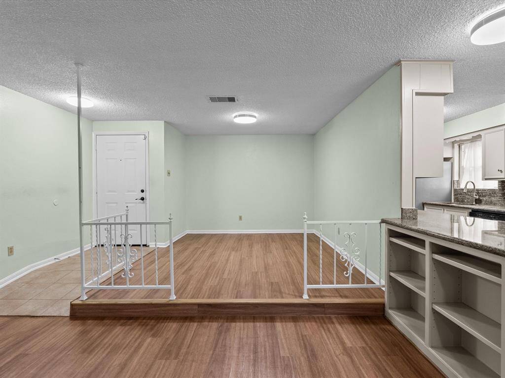 This primary bedroom room features wood like flooring, with a ceiling fan for comfort. It includes a full closet with wooden sliding doors and an en-suite bathroom.