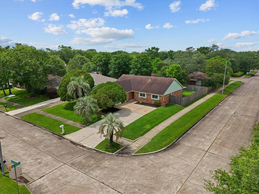 Ariel view of suburban home, mature trees, and yard, corner lot
