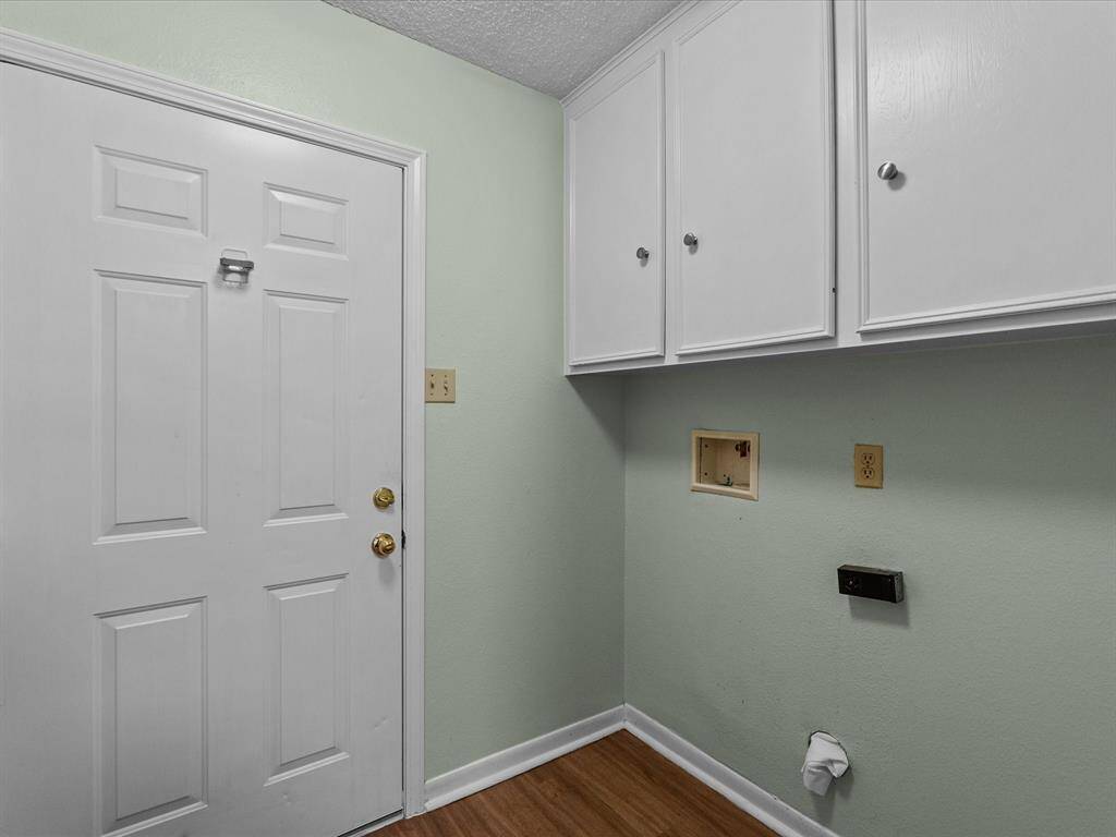 Laundry room with lots of cabinets, both electric and gas connections.