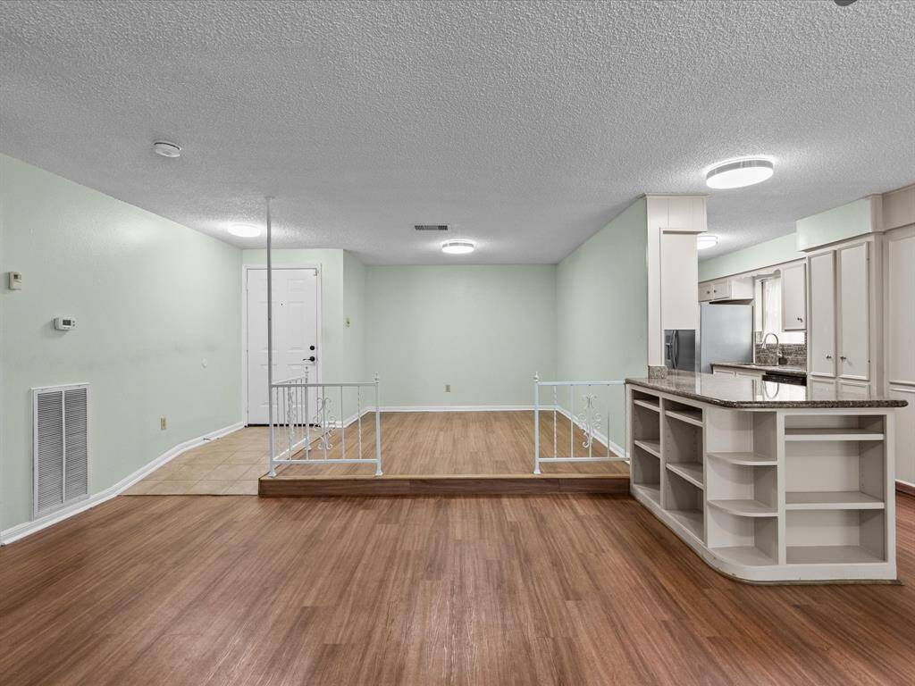 Large decor formal dining room with built in cabinets and storage, opens to a spacious living area.
