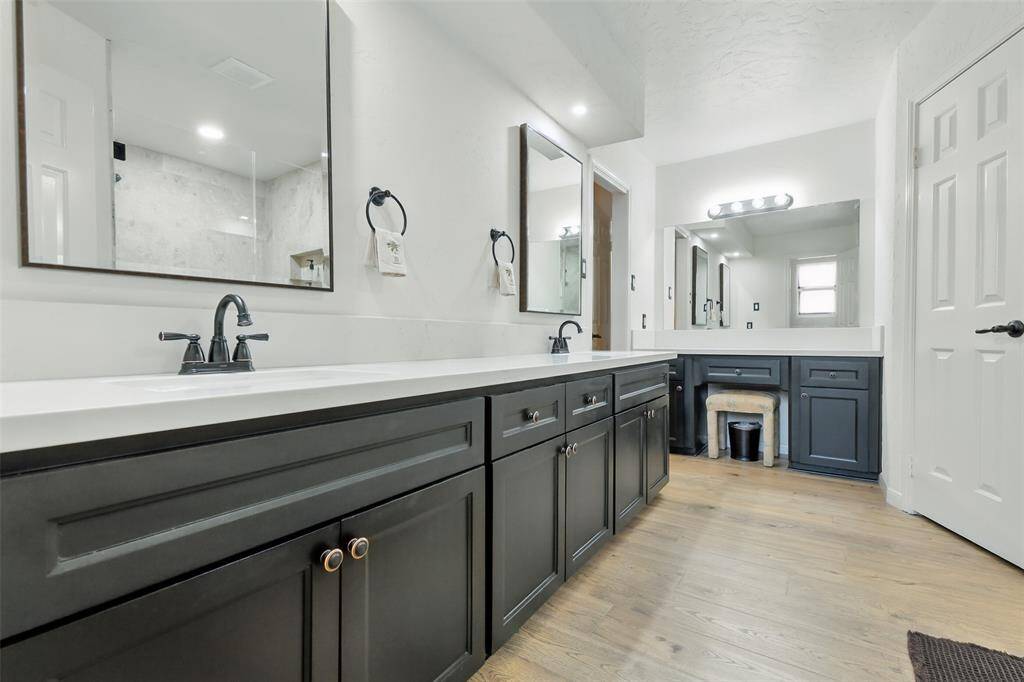 The primary bathroom features quartz counters, updated cabinetry, double sinks, dual vanities, two walk-in closets and luxury vinyl plank floors (2023).